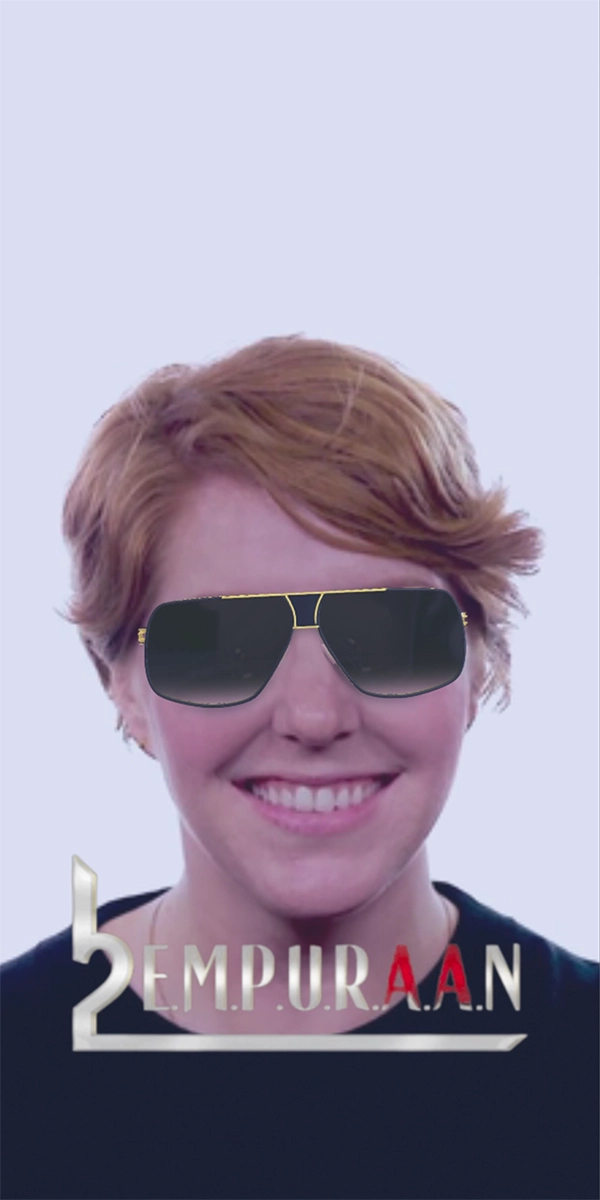 A smiling lady with short hair wearing black sunglasses, with the word 'empuraan' in stylized font below, perfect for an Instagram post